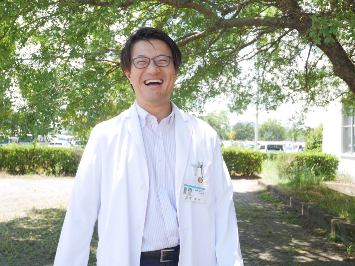 木陰で笑顔を見せるもりざね先生