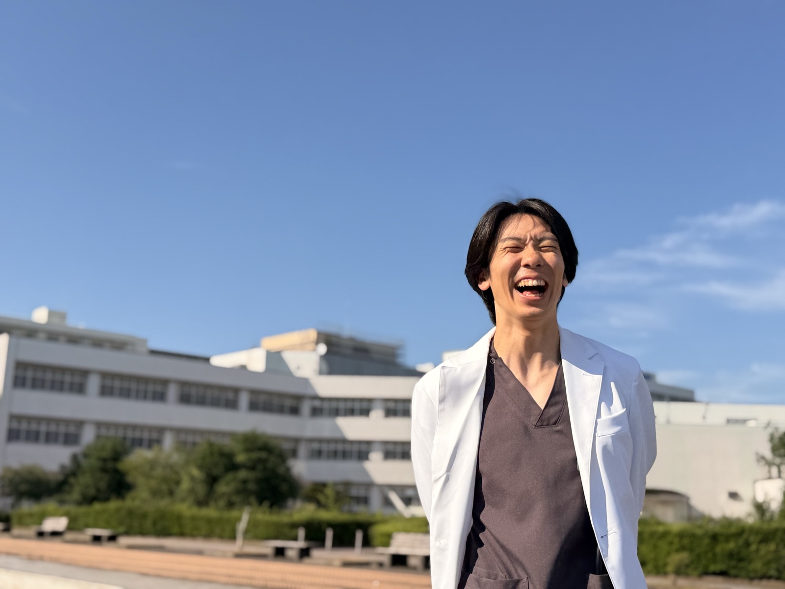 青空の下で笑う若手医師